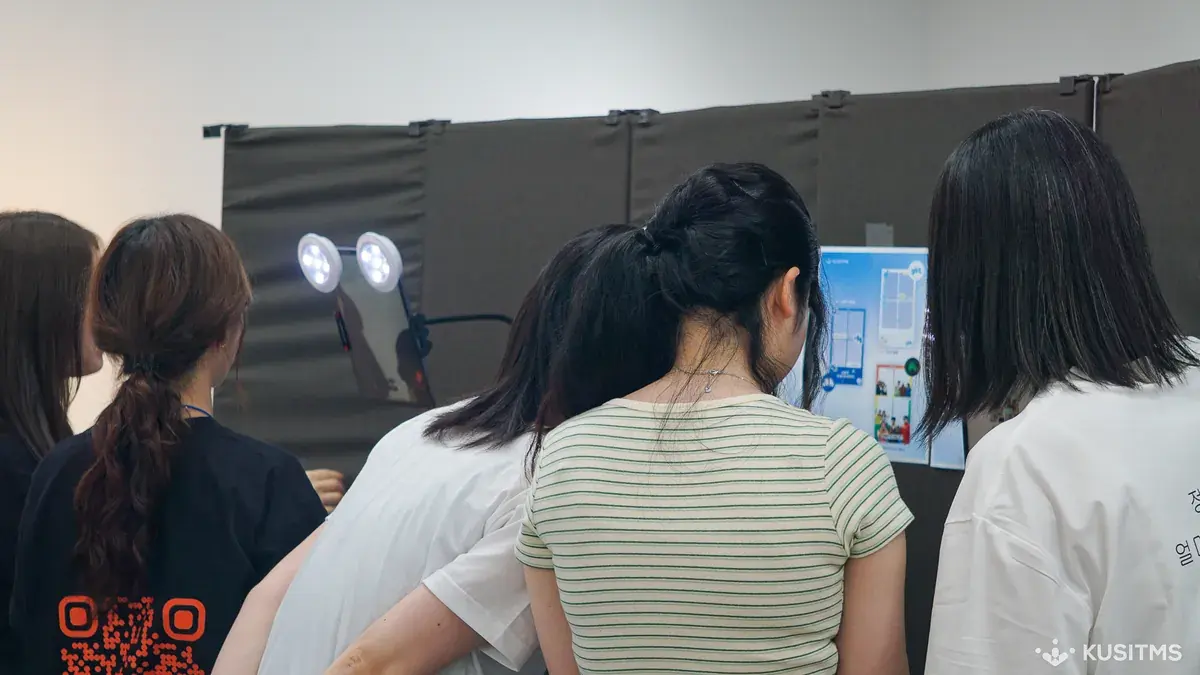 Visitors taking four-cuts at an exhibition team booth
