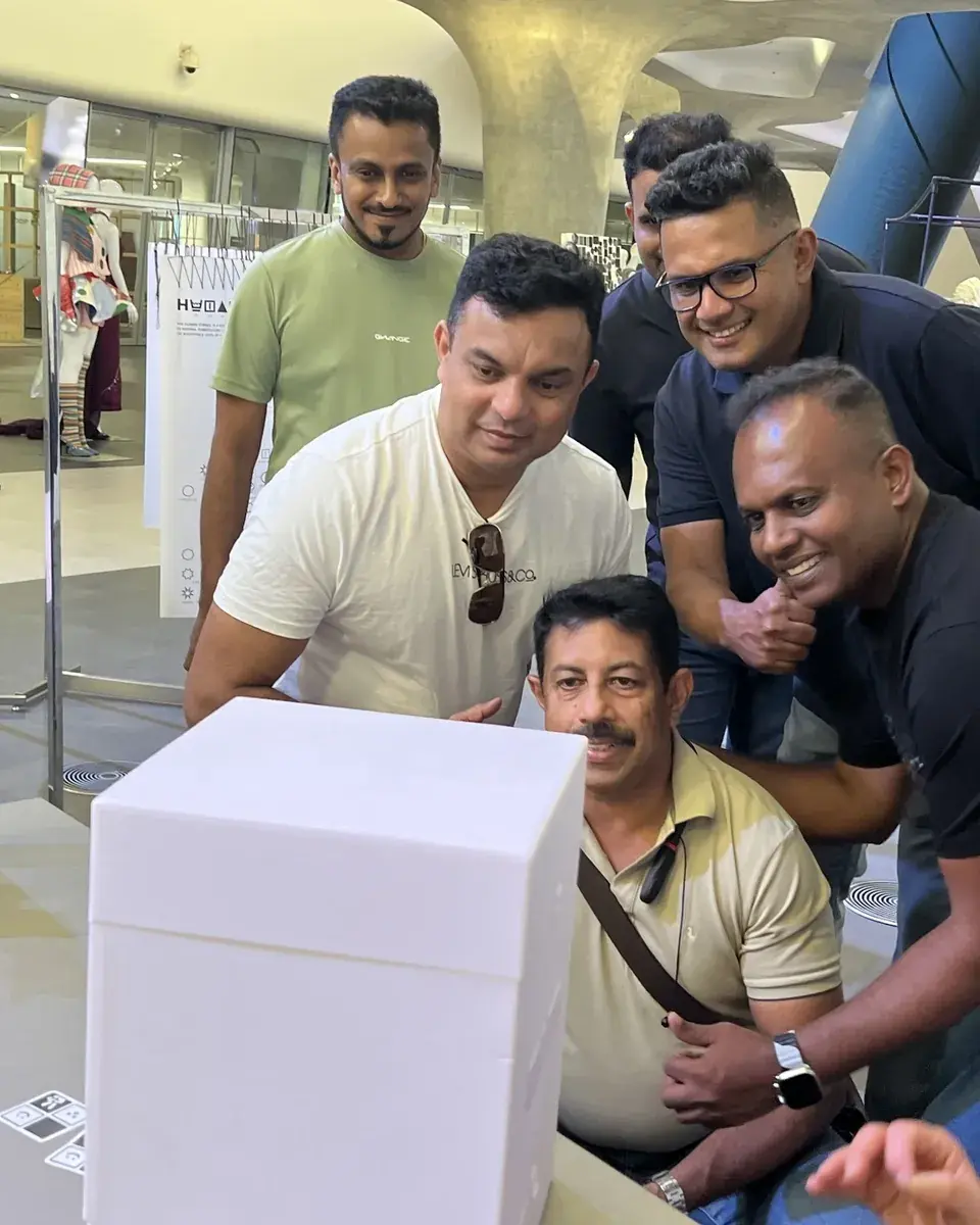 People smiling around a white my4cut mini booth backstage at a fashion show