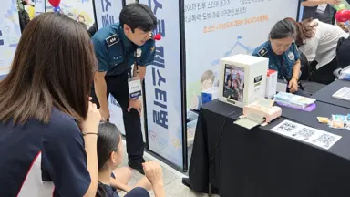 Police officers and students taking photos with a my4cut mini booth at a youth prevention event