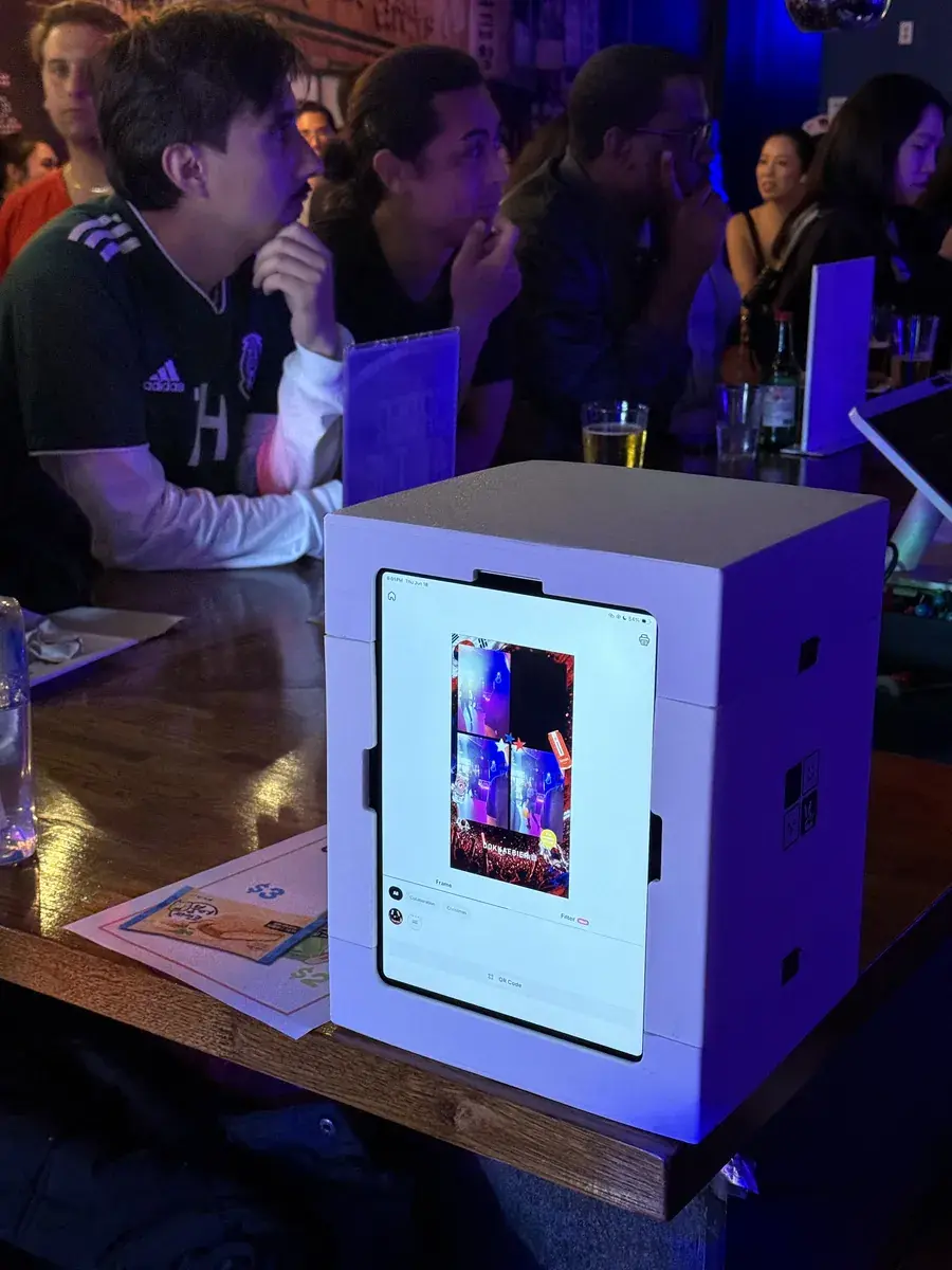 A my4cut mini photo booth running under blue light on a bar counter in San Francisco