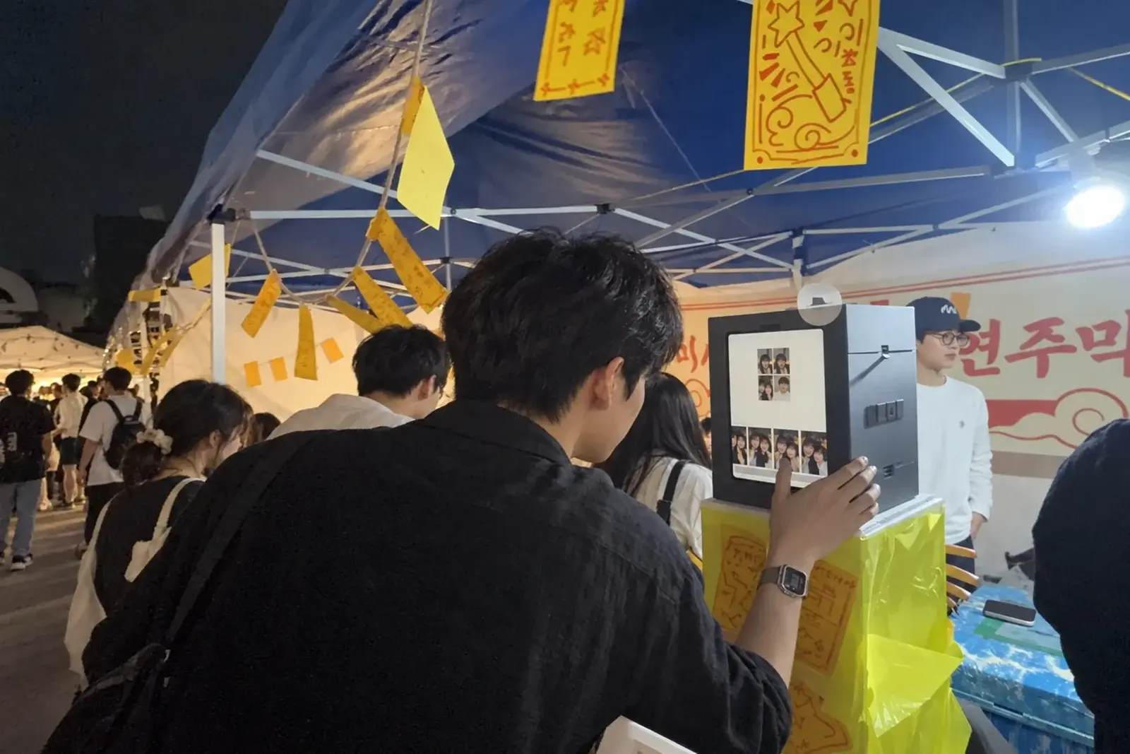 밤 대학 축제 천막 아래 미니 포토부스를 쓰는 사람들